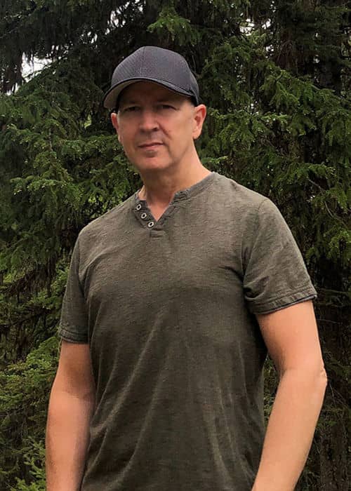 A portrait of Chef Andre with a forest background